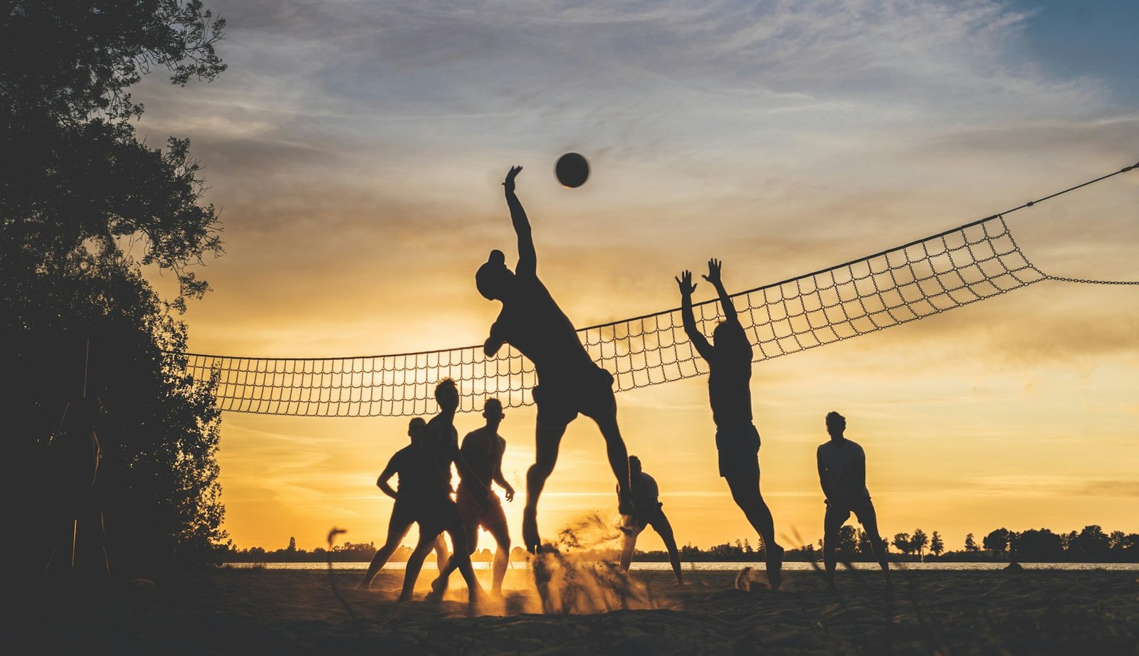 Jogadores na areia ao pôr do sol