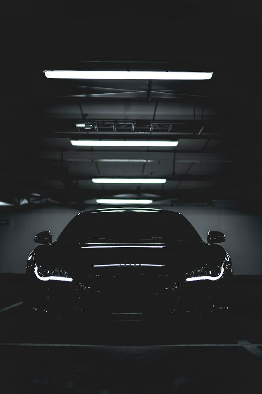 Carro esportivo preto em garagem iluminada