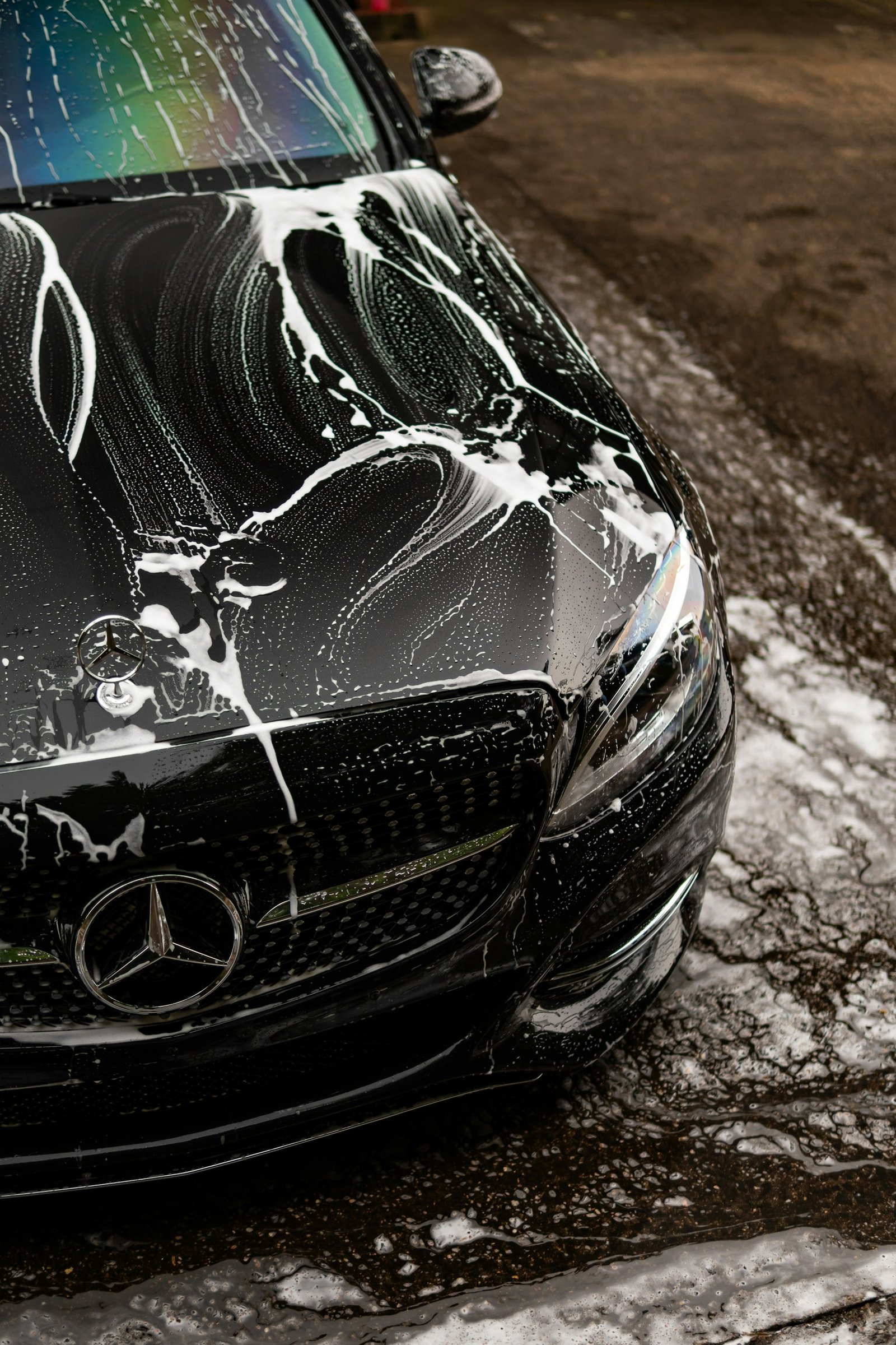 Carro preto coberto de espuma durante a lavagem