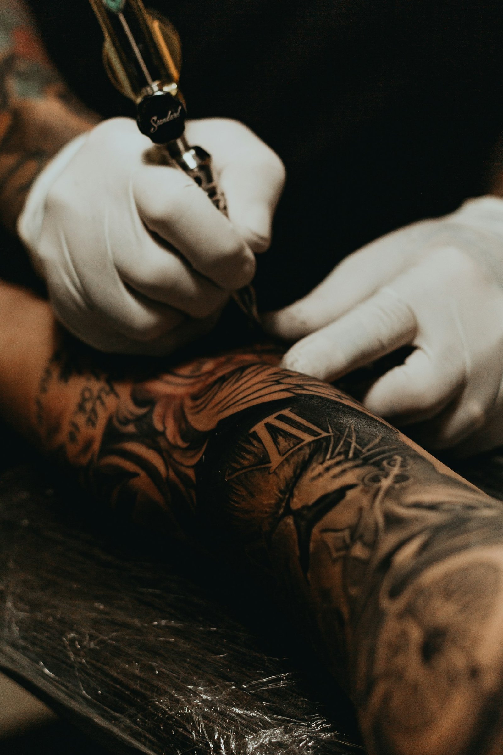 Tatuador trabalhando em um braço